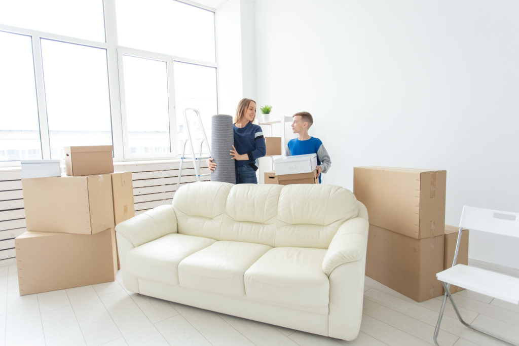 Young cute single mother and son are happy about the move to new house holding a pot of greens and